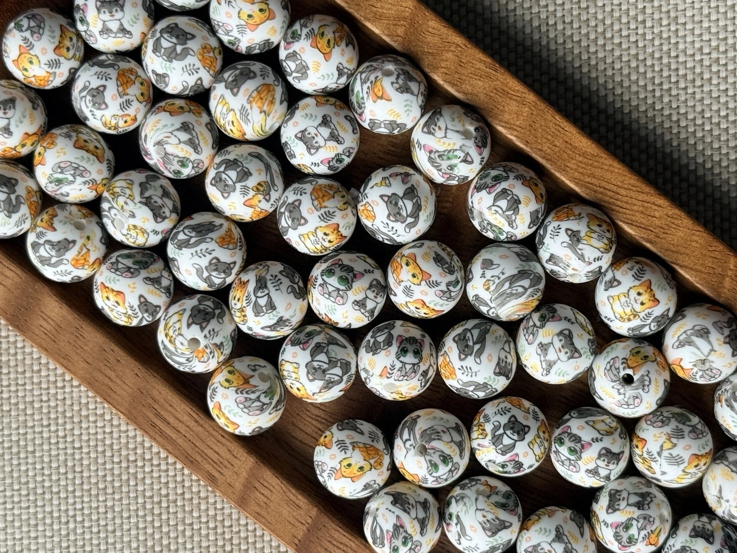 Purrfectly Playful 15mm printed silicone bead featuring colorful gray, orange and green cats and kittens on a light background for beaded crafts.