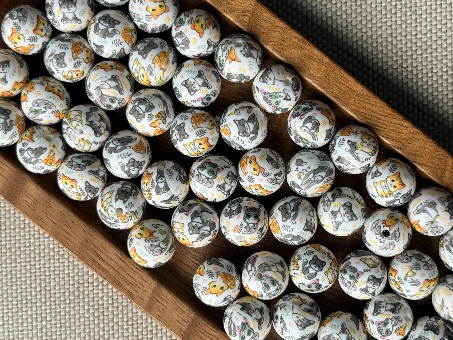 Purrfectly Playful 15mm printed silicone bead featuring colorful gray, orange and green cats and kittens on a light background for beaded crafts.