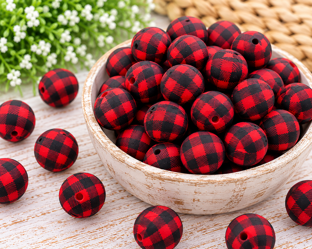 Close-up of red and black buffalo plaid 15mm round silicone beads in a wooden bowl for handmade wristlet keychains.