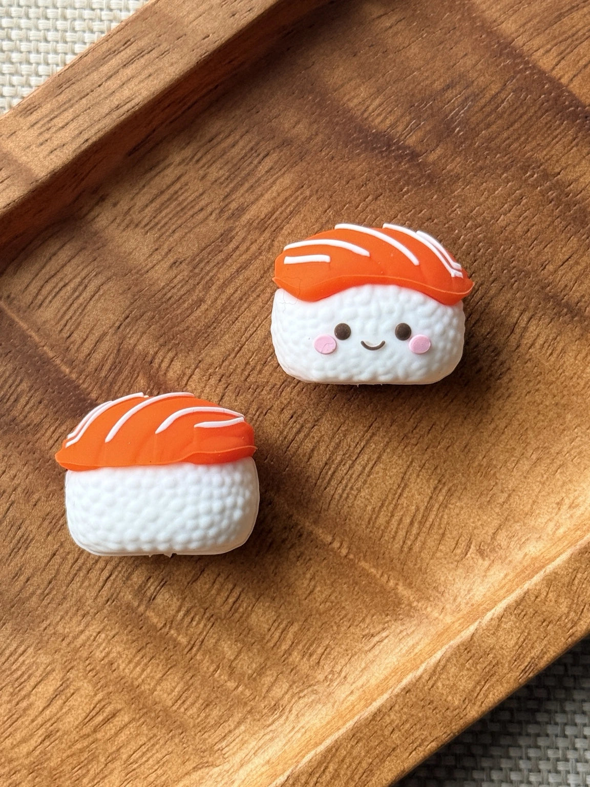 Salmon Smiles sushi silicone focal bead featuring orange salmon, textured white rice, pink cheeks and a cute smiling face for DIY beaded accessories.