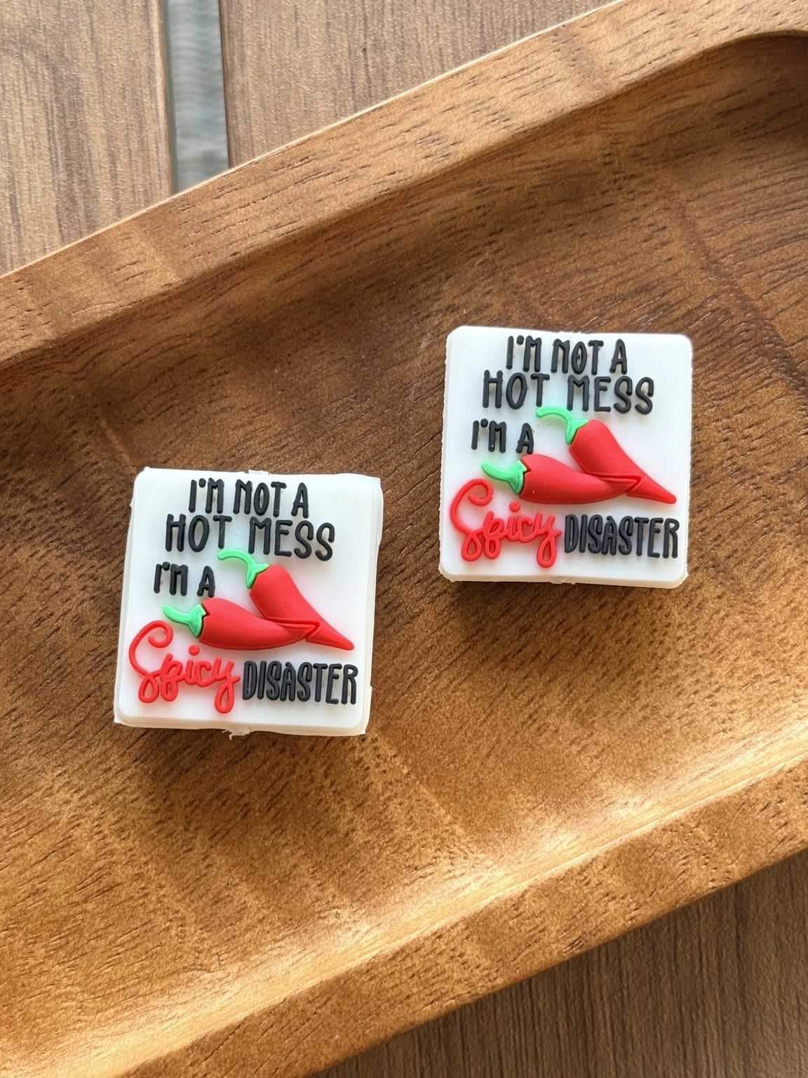 Silicone focal bead featuring the phrase “I’m Not a Hot Mess, I’m a Spicy Disaster” with red chili peppers. Perfect for beadable pens, keychains, wristlets, badge reels, and DIY craft projects.
