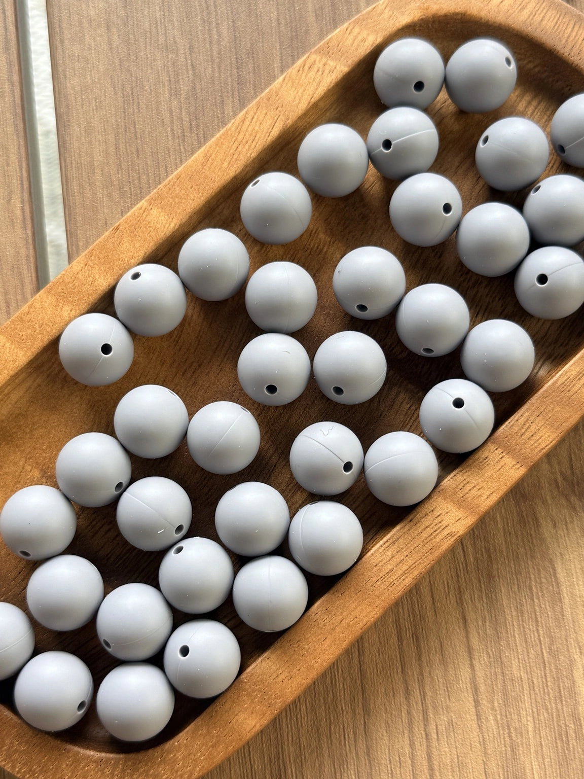 Gray 15mm matte silicone round beads displayed in a wooden tray for crafting, beadable pens, jewelry making, wristlets, and DIY accessories.