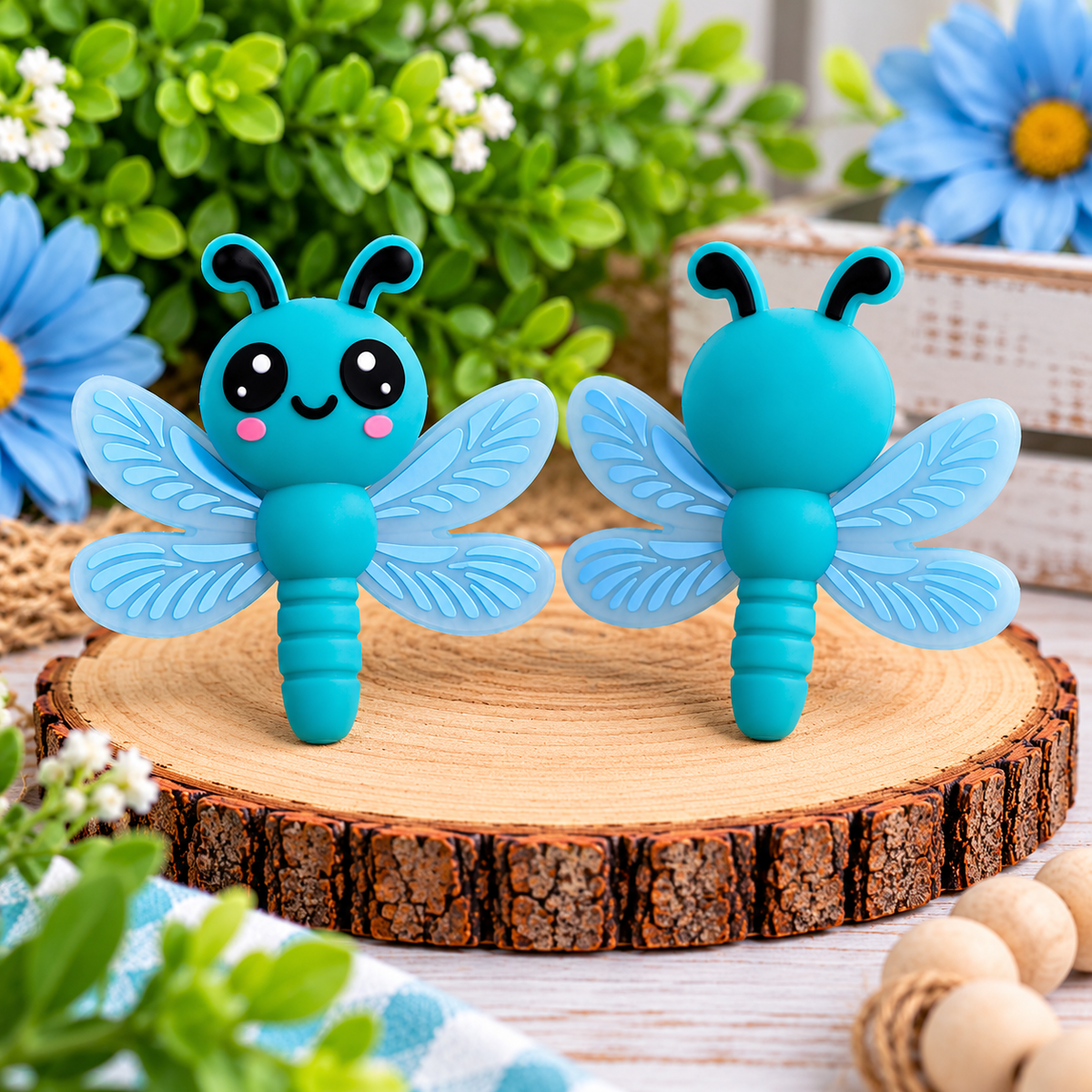 Cute teal dragonfly silicone focal bead with light blue detailed wings, black eyes, and pink cheeks for DIY wristlets, keychains, and beaded crafts.