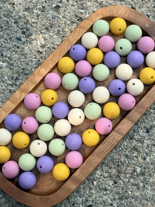 Vintage Pastel 15mm silicone bead mix featuring Pistachio Mist, Rosy Reverie, Midnight Orchid, Sandy Dune and Golden Daffodil. Includes 60 beads with 12 of each color.